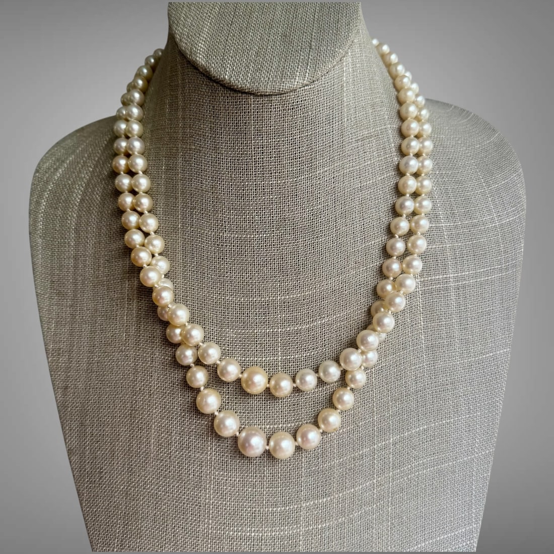 Vintage 14K Gold Cultured Pearl Necklace with Gemstone Clasp: Elegant vintage cultured pearl necklace featuring luminous graduated pearls and a striking multi-row gemstone clasp accented with pearls, rubies, and blue sapphires. The necklace displays beautiful wa