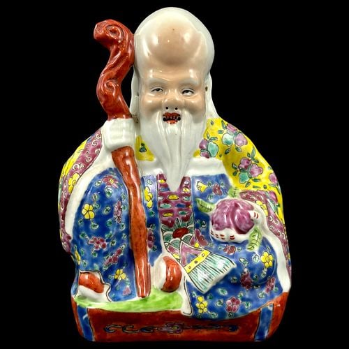 Chinese Famille Rose Porcelain Figure of Shou Lao God of Longevity: A colorful Chinese porcelain figure depicting Shou Lao, the God of Longevity, modeled seated with a tall domed forehead, flowing white beard, and a red staff held at his side. The figure is decorated 
