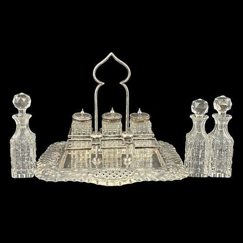 Victorian Silverplate & Cut Glass Six-Bottle Cruet Set with Reticulated Floral Tray: An ornate Victorian-style cruet and condiment stand featuring a shaped silverplate tray with pierced lattice panels, repoussé floral and scroll decoration, and a tall arched central handle. The