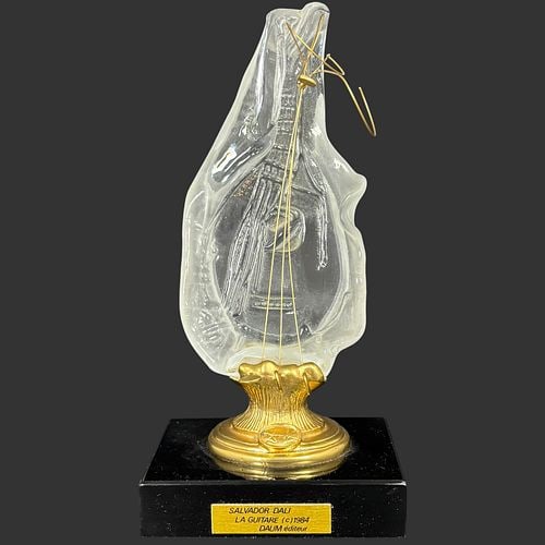 Salvador Dali La Guitare Daum Crystal Sculpture Dated 1984: Salvador Dali “La Guitare” crystal sculpture, produced by Daum éditeur in 1984, featuring a molded clear and frosted glass guitar-form body with relief musical imagery, gilt metal s
