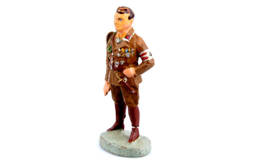1 German Field Marshal Göring, Elastolin,: 1 Göring stehend in SA-Uniform mit Dolch, beweglicher Grußarm (sehr locker), Elastolin, 7,5 cm-Größe, originale Bemalung, leicht farblich fachmännisch ausgebessert, am Kopf te