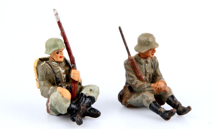 1 German Pioneer and 1 Infantryman sitting, Lineol and: 1 Pionier sitzend ohne Kochgeschirr, Elastolin; 1 Infanterist sitzend für Ponton, Lineol, kleiner Masseverlust am Gewehr, 7,5 cm-Größe, originale Bemalung, leicht berieben, kleine Risse