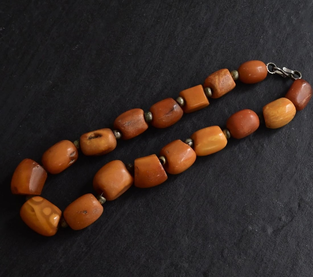 Antique Tibetan Butterscotch Amber Necklace 77.71g 15.25" Barrel Beads: This beautiful antique Tibetan necklace features a stunning strand of butterscotch amber beads in classic barrel and nugget shapes, showcasing the warm, natural hues and organic textures characteristi
