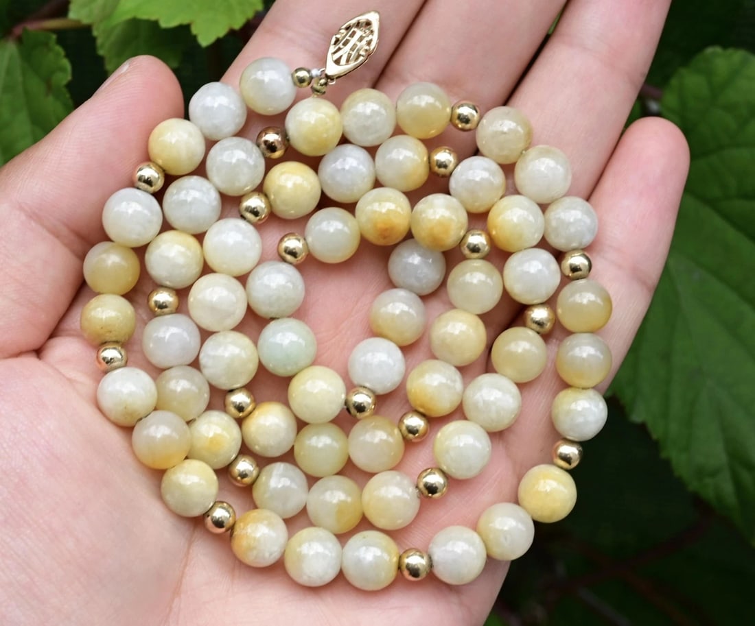 IGI Certified Natural Jade Bead Necklace – 14K Yellow Gold Clasp, 23" Length: This elegant and certified natural jade necklace is a timeless expression of organic beauty and fine craftsmanship. Measuring approximately 23 inches in length, the piece is composed of 60 round jade