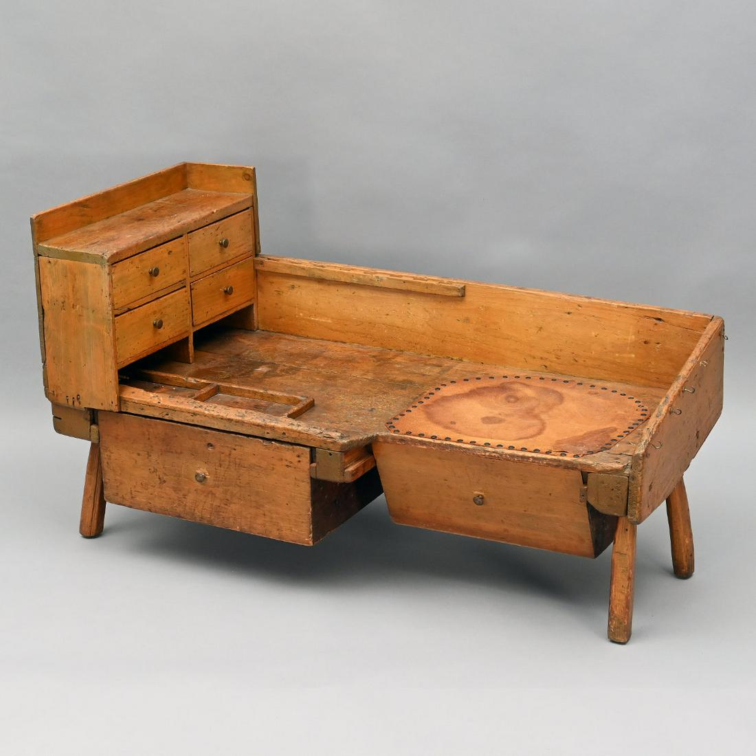 American Pine Cobbler's Bench Coffee Table.: American Pine Cobbler's Bench Coffee Table. The Oblong Top With Leather Surface, A Bank Of Four Short Drawers And Backsplash Above Two Deep Drawers, Raised On Splayed Legs. Height 27; Width 47; Depth