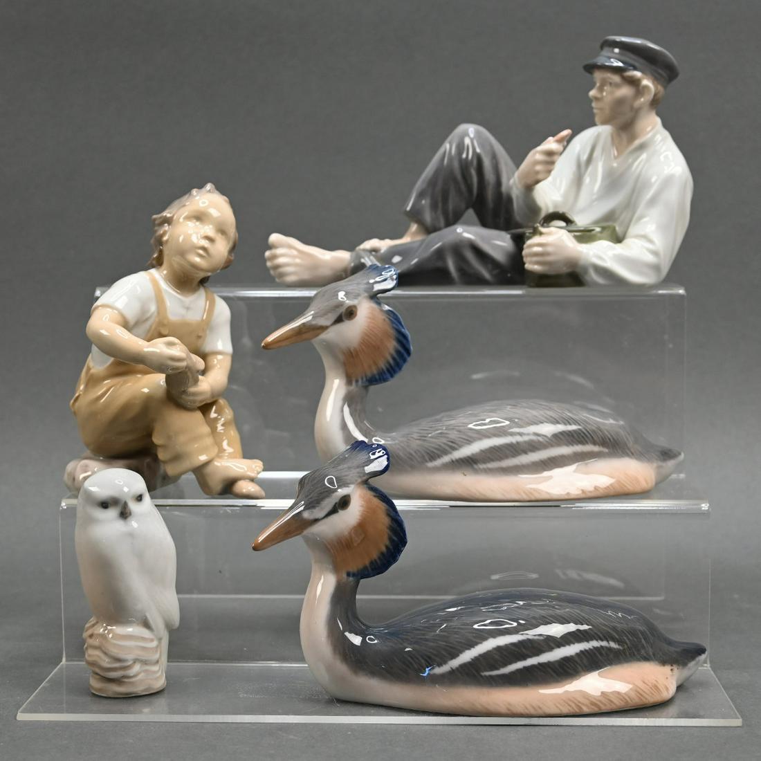 Four Royal Copenhagen Figures And Another: Four Royal Copenhagen Figures Including Two Depicting Grebe Water Birds #3263, A Figure Of A Boy At Lunch #853 And An An Owl 1741, Together With A Bing & Grondahl Figure Of A Boy Holding A Shoe #2275.