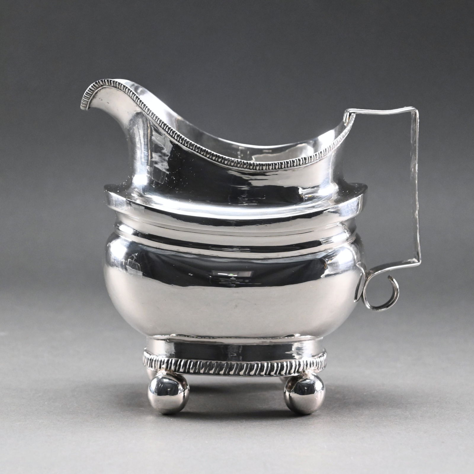 New York Classical Silver Creamer, J.W. Forbes: John Wesley Forbes, Active 1808-1838. The body of helmet form with gadrooned rim and foot, raised on ball feet. Monogramed and dated 1812. H: 5.25 in., W: 5.5 in., D: 3.5 in. 7.5 troy ounces.