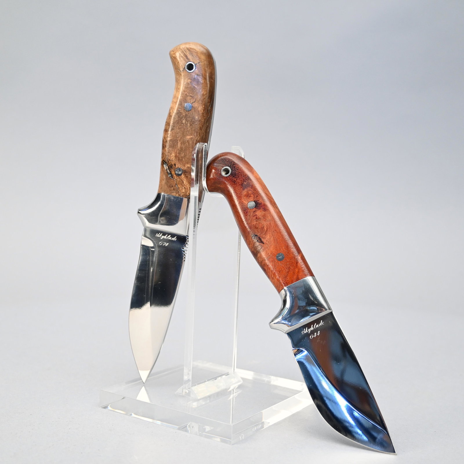 Two Custom Skyblade Knives By Tom Orr: Two custom fixed blade knives by Tom Orr, Bozeman, Montana: a drop point hunter blade, #074 and drop point skinner blade #44, each with burl handles and leather sheaths by Madison Saddlery, Ennis, Mon