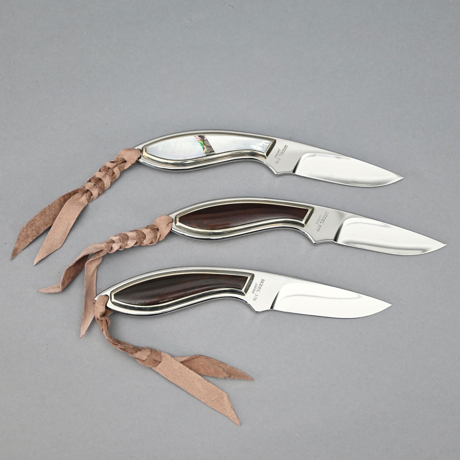 Three Browning Fixed Blade Knives: Each 7 inches overall with fitted leather cases. Models #376 & #377 with inlaid hardwood grips; model #378 with inlaid mother of pearl and abalone handle. Blade lengths: 3.25 inches. Overall lengths: