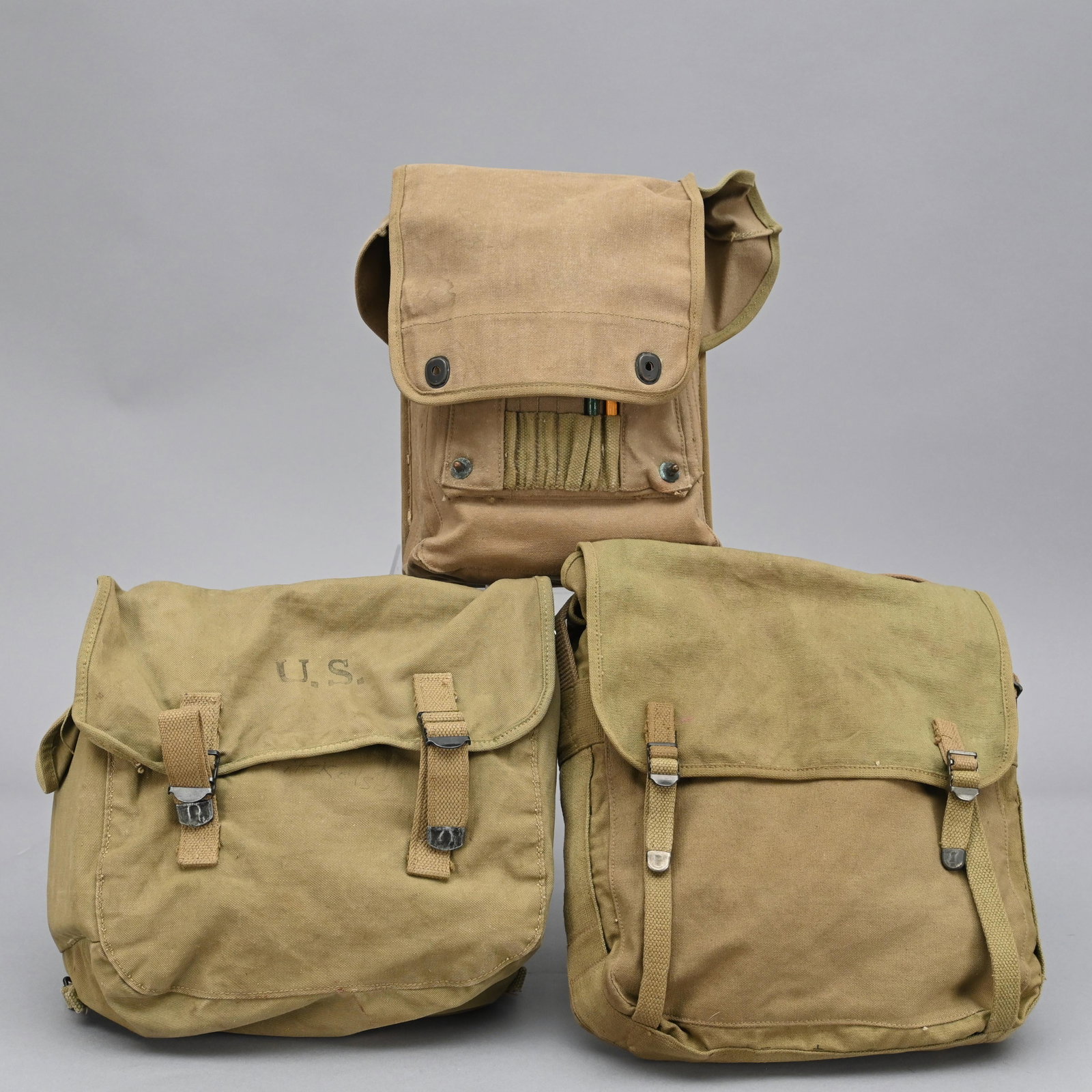 Lot of Three US WWII Canvas Field Bags: Includes the following: - 1942 Varied Mfg. US M1936 Musette bag - 1942 USMC Boyt USMC M1941 Combat Field bag - 1942 USMC Boyt Map/Medic bag H: 11 in., W: 14 in., D: 5.5 in. (first)
