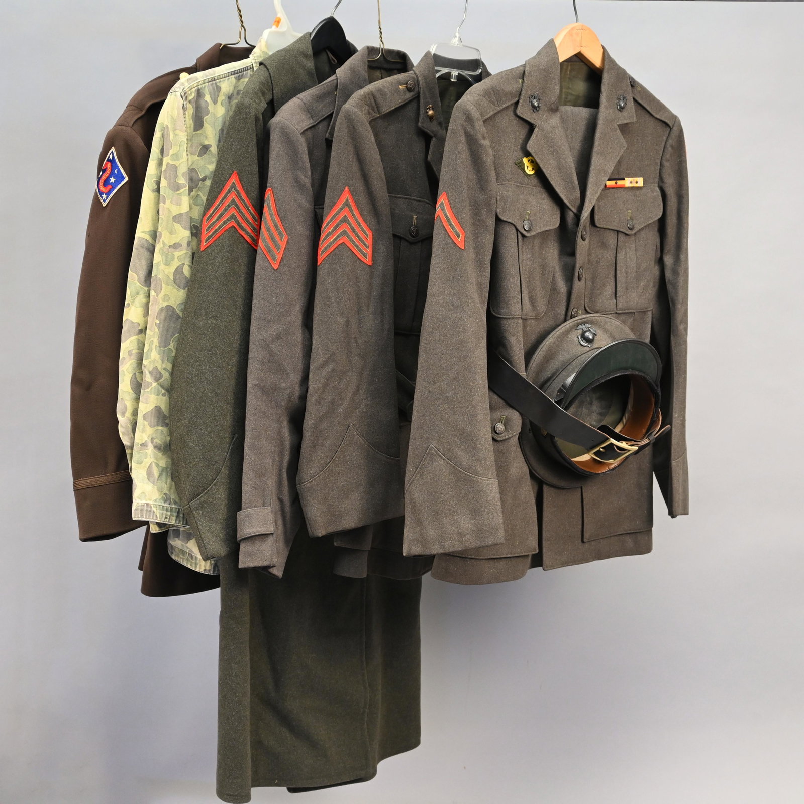 Military Lot Including USMC Uniforms & Accessories: Including five hats, three jackets, a pair of trousers, an overcoat, a VFW jacket and a camouflage shirt.