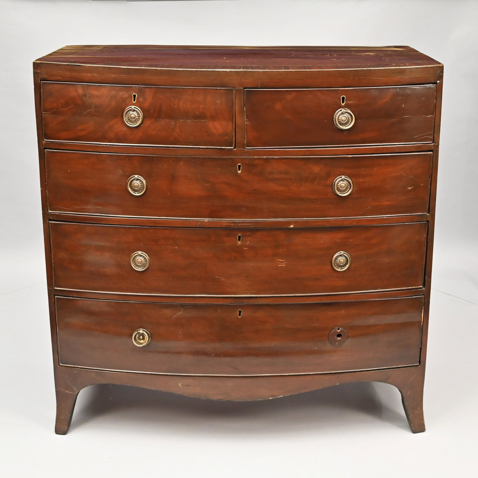 George III Mahogany Bow-Front Chest of Drawers: The oblong top with bowed front above a conforming case of cockbeaded drawers with two short drawers above three long drawers, over an arched apron, raised on French feet. H: 42 in.; W: 41.5 in.; D: 2