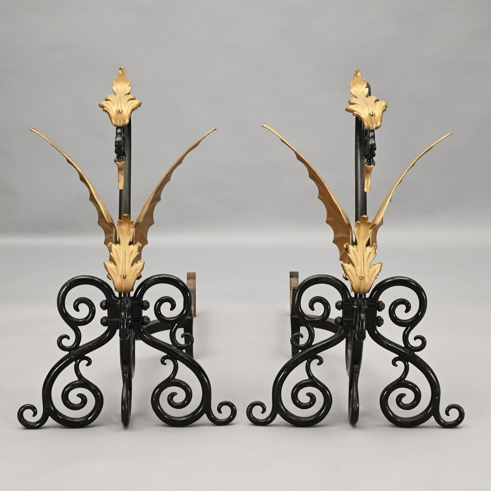 Pair of Bradley & Hubbard Griffith-Form Andirons: Each with open-mouth and arched neck above flared wings, raised on a scrolled base. Marked B & H, #9533. H: 26.25 in., W: 16.25 in., D: 30 in.