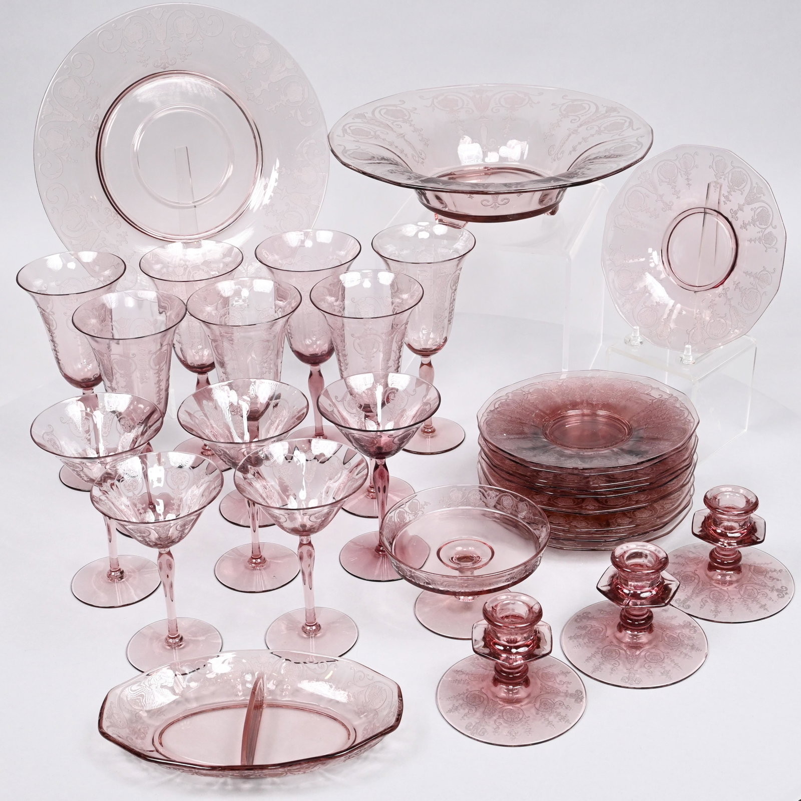 American Etched Amethyst Glass Service, Circa 1940: Comprising 1 console bowl and liner, 3 candlestick holders, 1 divided dish, 1 small footed tazza, 7 goblets and 5 wine glasses. (19) Height of console bowl and liner 3.25 in., Diam.: 12.25 in.