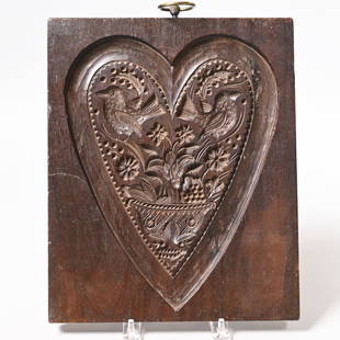 American Carved Walnut Cakeboard, J. Conger: John Conger (ca. 1803-1869), New York, New York, Circa 1830. Carved with a pair of birds perched on a basket of flowers, within a smooth heart-shaped border, marked "J. CONGER" on the bottom edge. H: