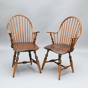 Pair of New York Continuous Arm Windsor Chairs: Well-turned arm supports centering the spindle backs, above shaped saddle seats, raised on turned tapered legs, joined by an H-form stretcher. H: 37 in.; W: 22 in.; D: 21 in. (approx.)