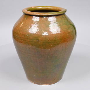 American Redware Green-Glazed Storage Jar: Likely New England, Nineteenth Century. Of ovoid form in pale green glaze, the well-defined rolled rim above a bulbous shoulder tapering to the base. H: 12 in., Diam.: 10.5 in.