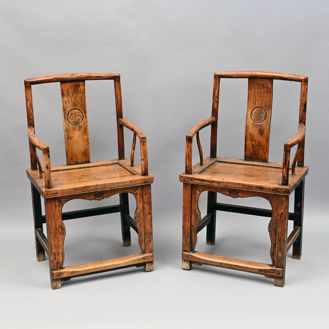 Pair Of Chinese Elm Armchairs: Pair of Chinese elm armchairs with incised yin and yang medallions. H: 40.5 in.; W: 23 in.; D: 19 in.