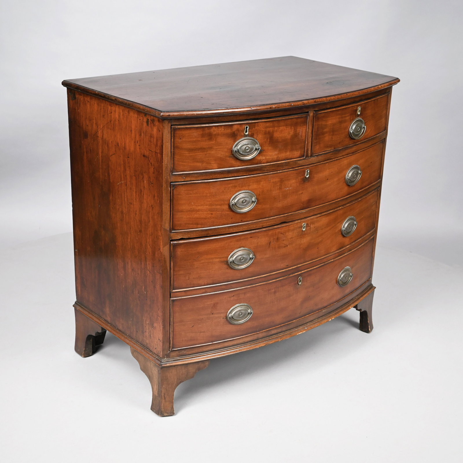 George III Mahogany Bow-Front Chest-of-Drawers: The bow-front top above two aligned over three cockbeaded graduated drawers, raised on a bracket base. H: 34.5 in., W: 36 in., D: 22.5 in.