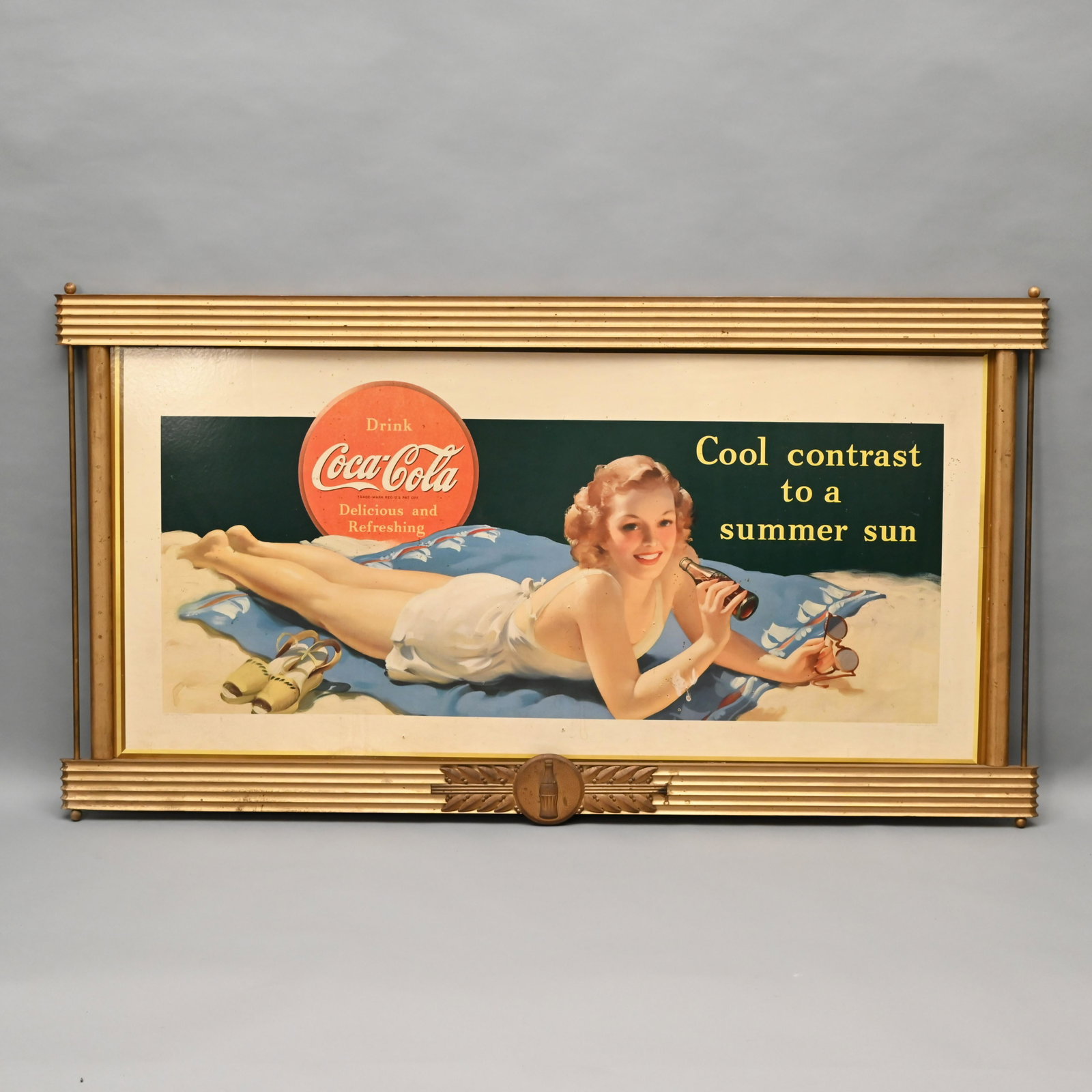 Coca Cola "Cool Contrast to A Summer Sun": "Drink Coca-Cola, Delicious and Refreshing," Framed Cardboard Advertising Sign, Circa 1941. Retaining the original wood and metal frame, as well as the tin Coca-Cola applique. H: 34 in., W: 64.5 in., 