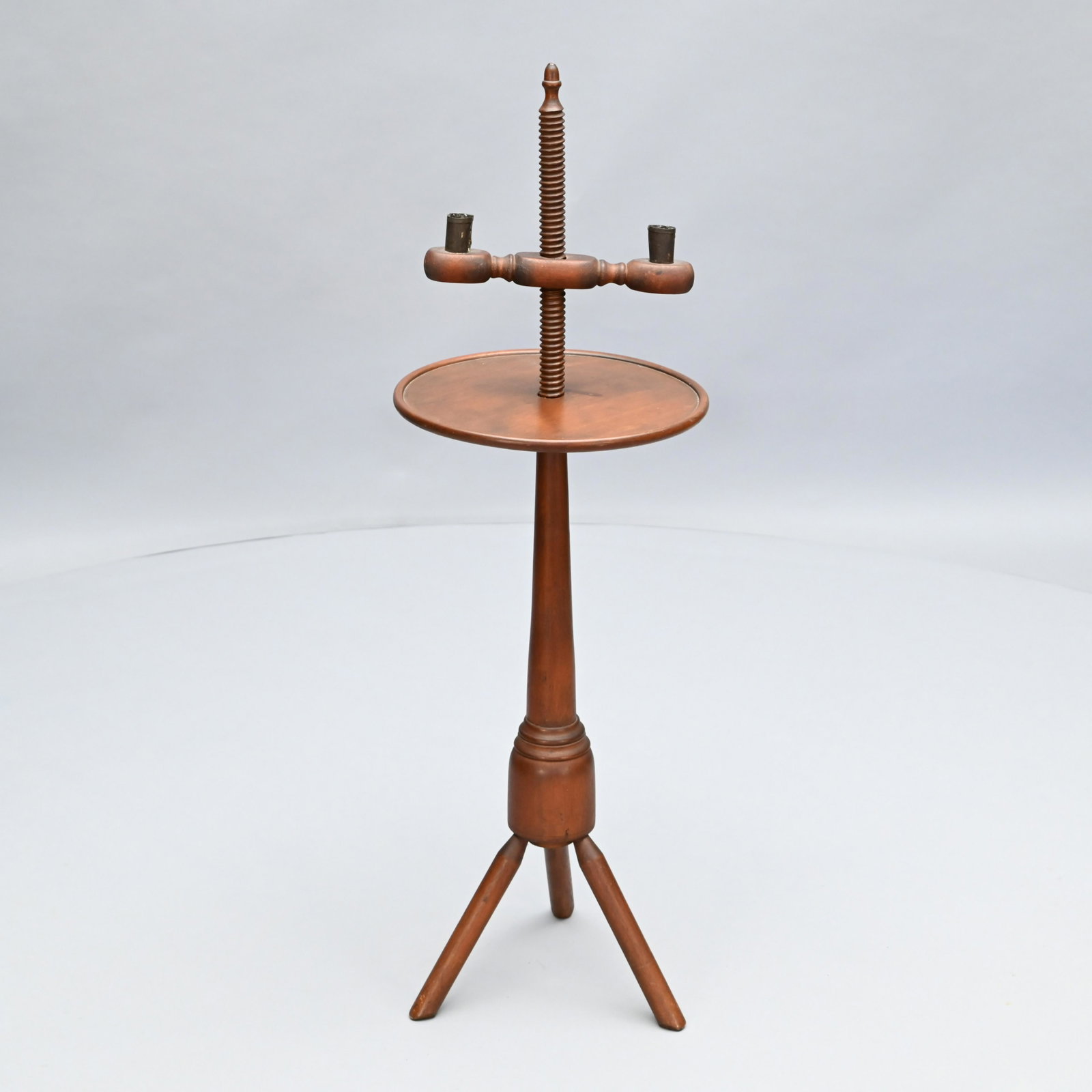 American Birch Adjustable Two-Light Candlestand: Likely Centennial, the screw-turned standard with acorn finial, the adjustable double candle arm with tin candle sockets above a circular dish top, over a turned shaft, raised on tripod feet.