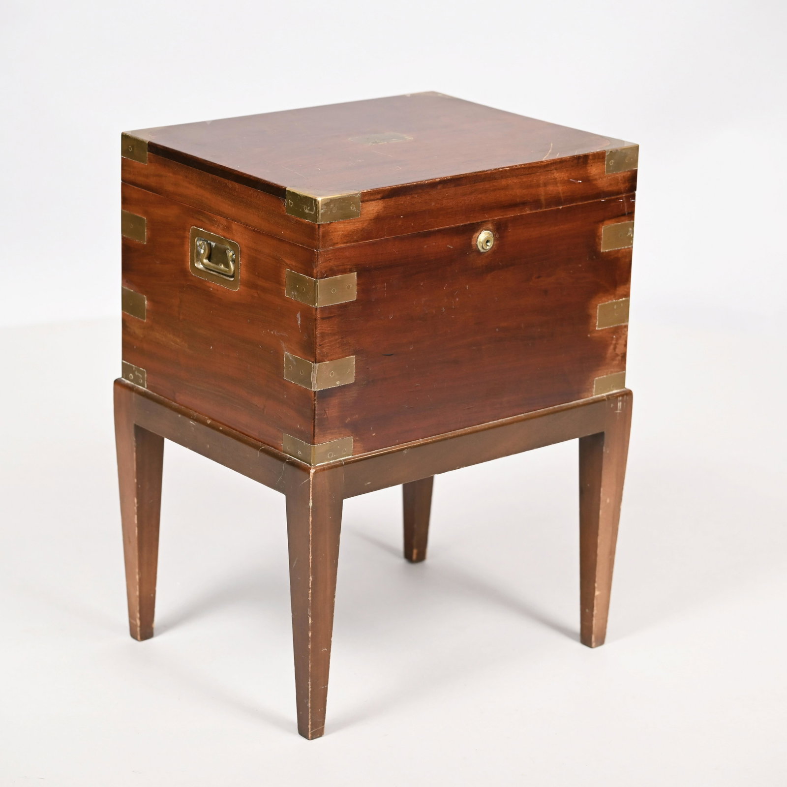Benson & Hedges Mahogany Humidor, 19th Century: Benson & Hedges Mahogany and Brass-Bound Humidor on Stand, London, Nineteenth Century. The rectangular top within brass corners and inlaid with a plaque engraved with the initials "S.L.B.," the lid op