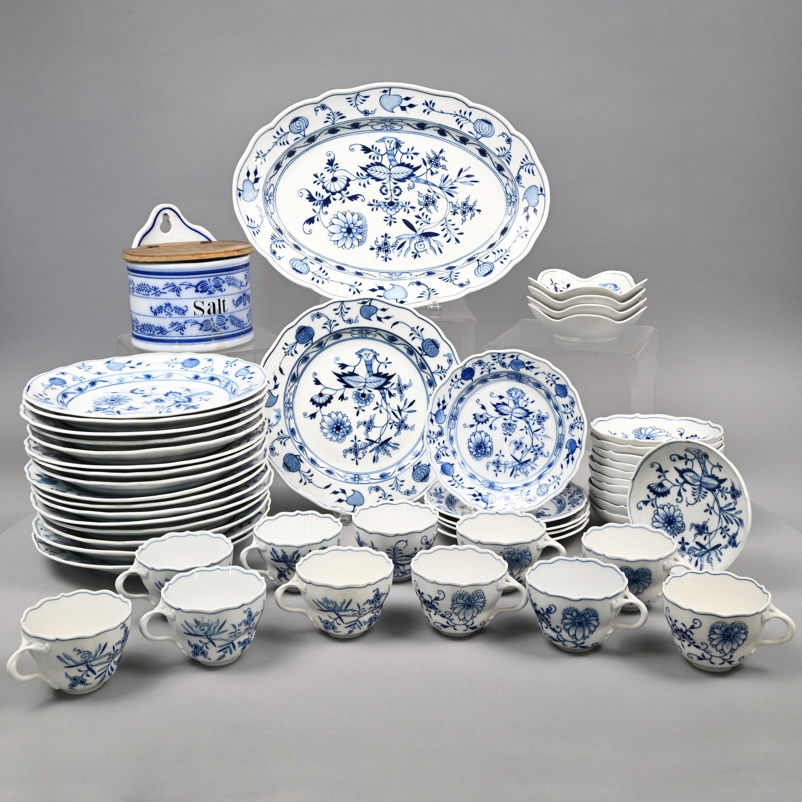 Meissen Porcelain 'Blue Onion' Part Dinner Service: Comprising one oval platter, eleven fruit dishes, four lobed bowls, five salad plates, five 9.875- inch plates, eleven 9.5- inch plates, eleven coffee cups, crossed swords mark in underglaze-blue, som