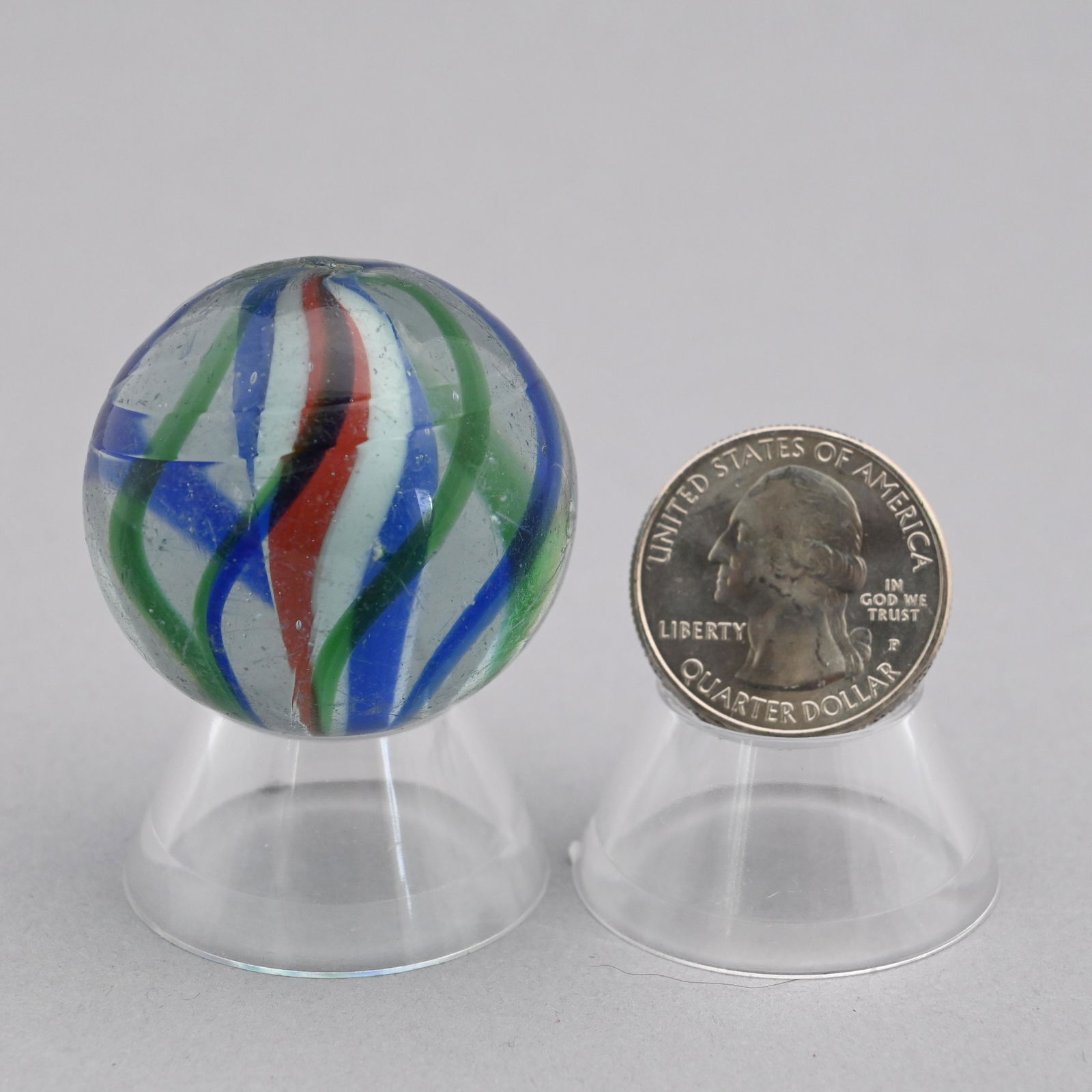 Large Solid Core Marble: Composed of cobalt blue and dark green swirls with a solid blue, rose and white white core. Diam: 1 25/64 in.