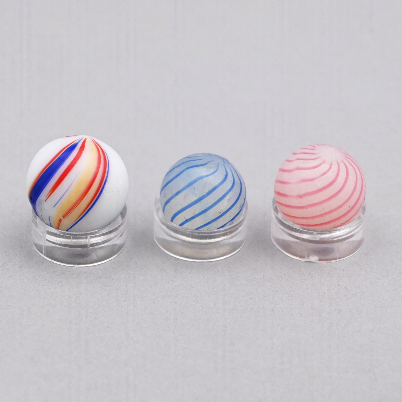 Two Clambroth Marbles & One Banded Opaque Example: The clambroth marbles swirled in pink and blue, the opaque marble in red, blue and yellow. Approximate range of diam: 9/16 to 21/32 in.