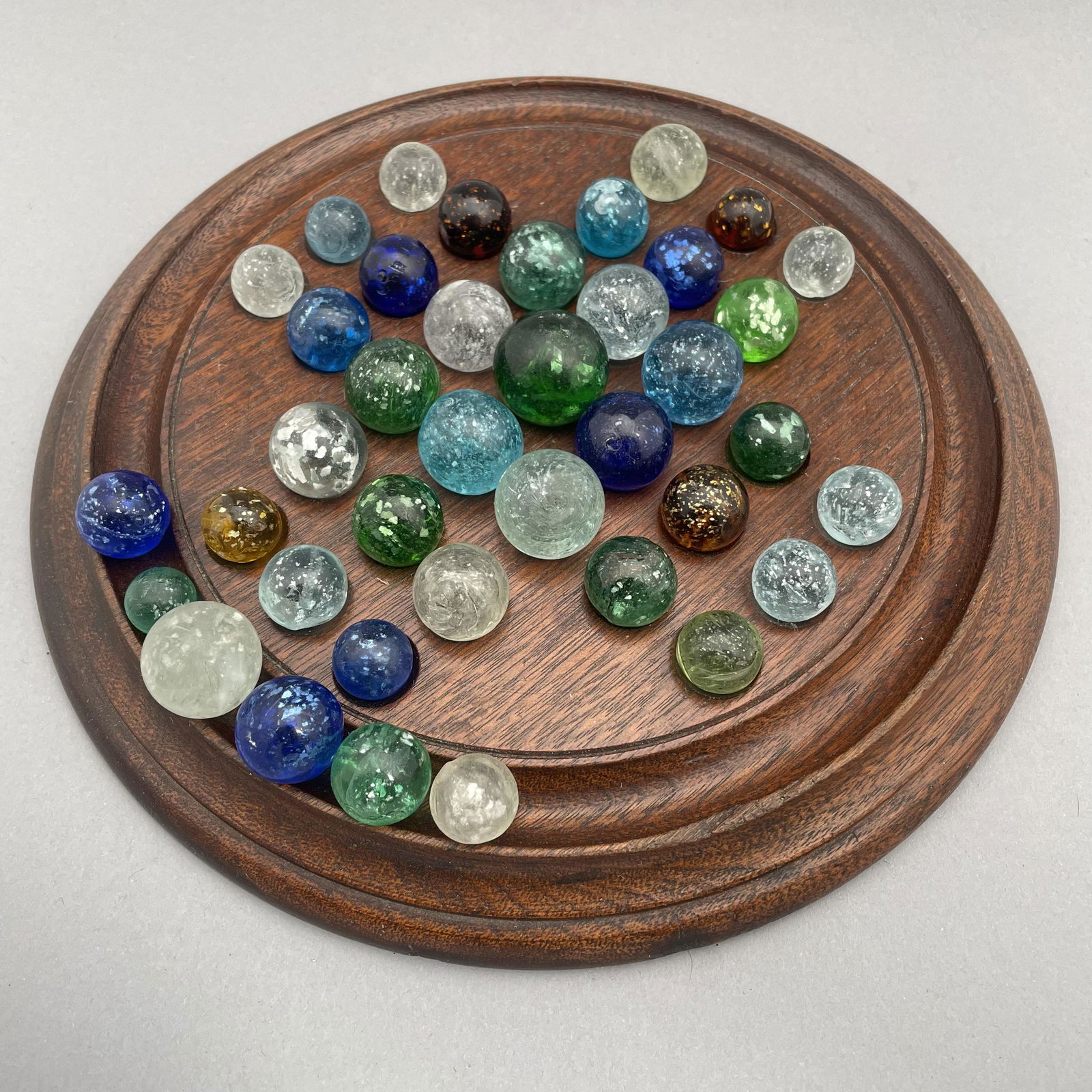 Solitaire Board with Thirty-Nine Mica Marbles: Approximate range of diam: 1/2 to 121/128 in. Board: Diam: 8.75 in., D: .75 in.