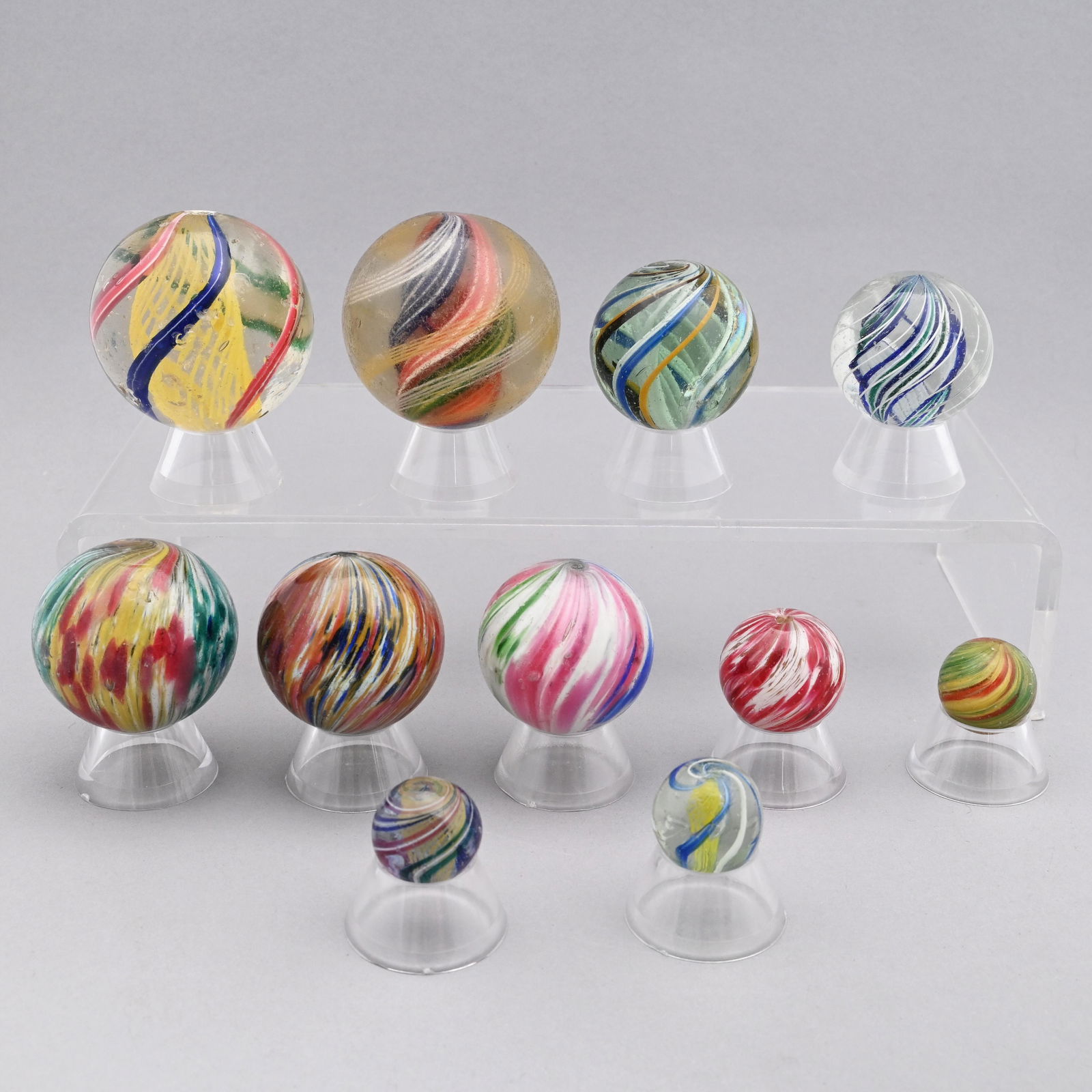 Eleven Handmade Swirl and Onion Skin Marbles: Approximate range of diam: 105/128 inch to 2 1/16 in.