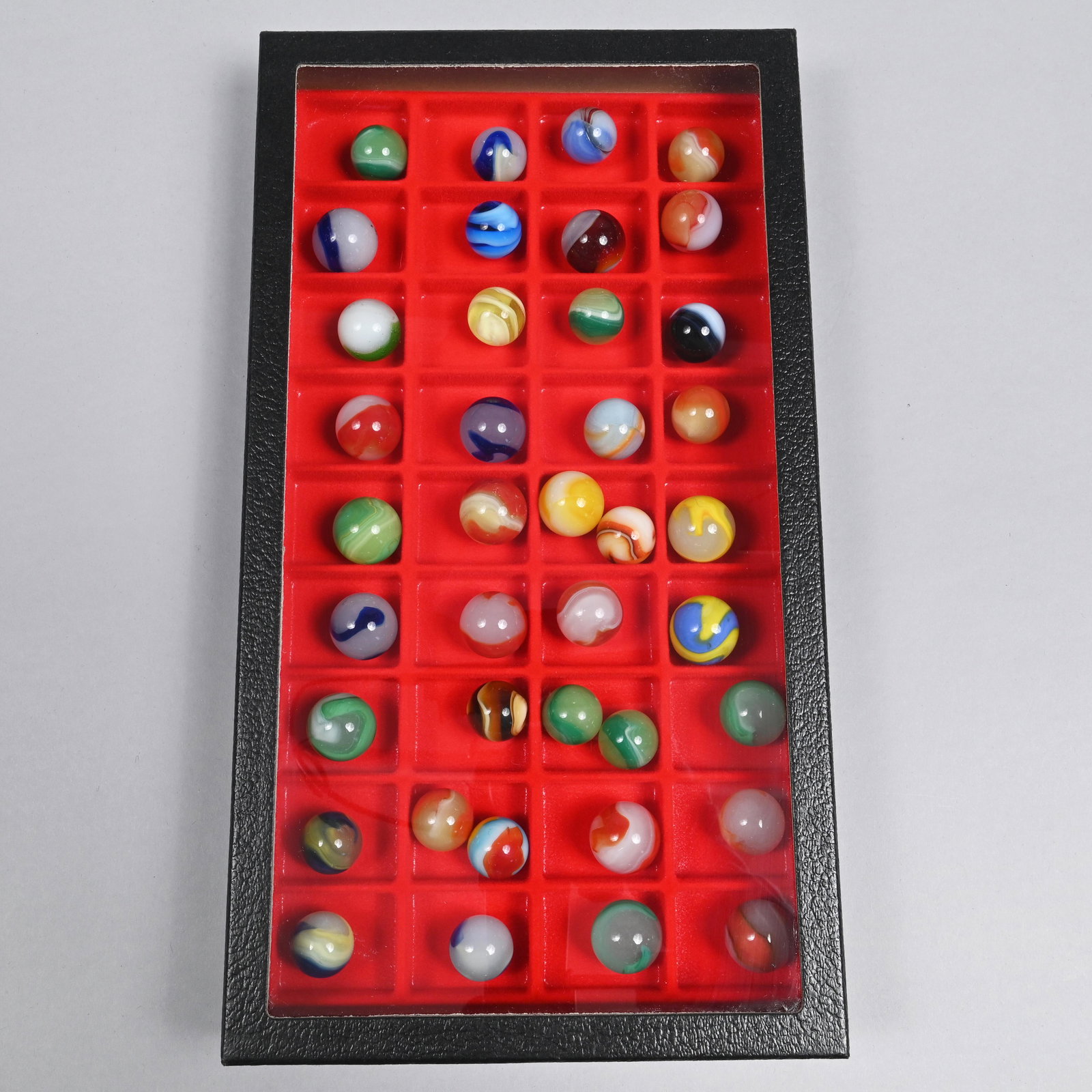 Group of Mostly Akro Agate Marble Shooters: Case: H: 8 in., W: 14.5 in., D: 1.75 in.