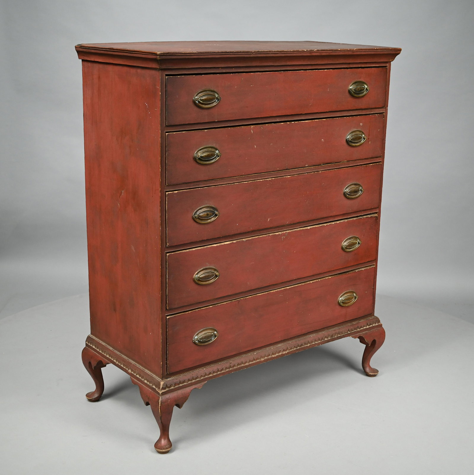 Queen Anne Maple Bandy Leg Tall Chest in Red Paint: In the manner of Samuel Dunlap (1752-1830), Henniker or Salisbury, New Hampshire, 1795-1810. The oblong top with cove-molded cornice above a case of five long drawers, over a flowered ogee molded base