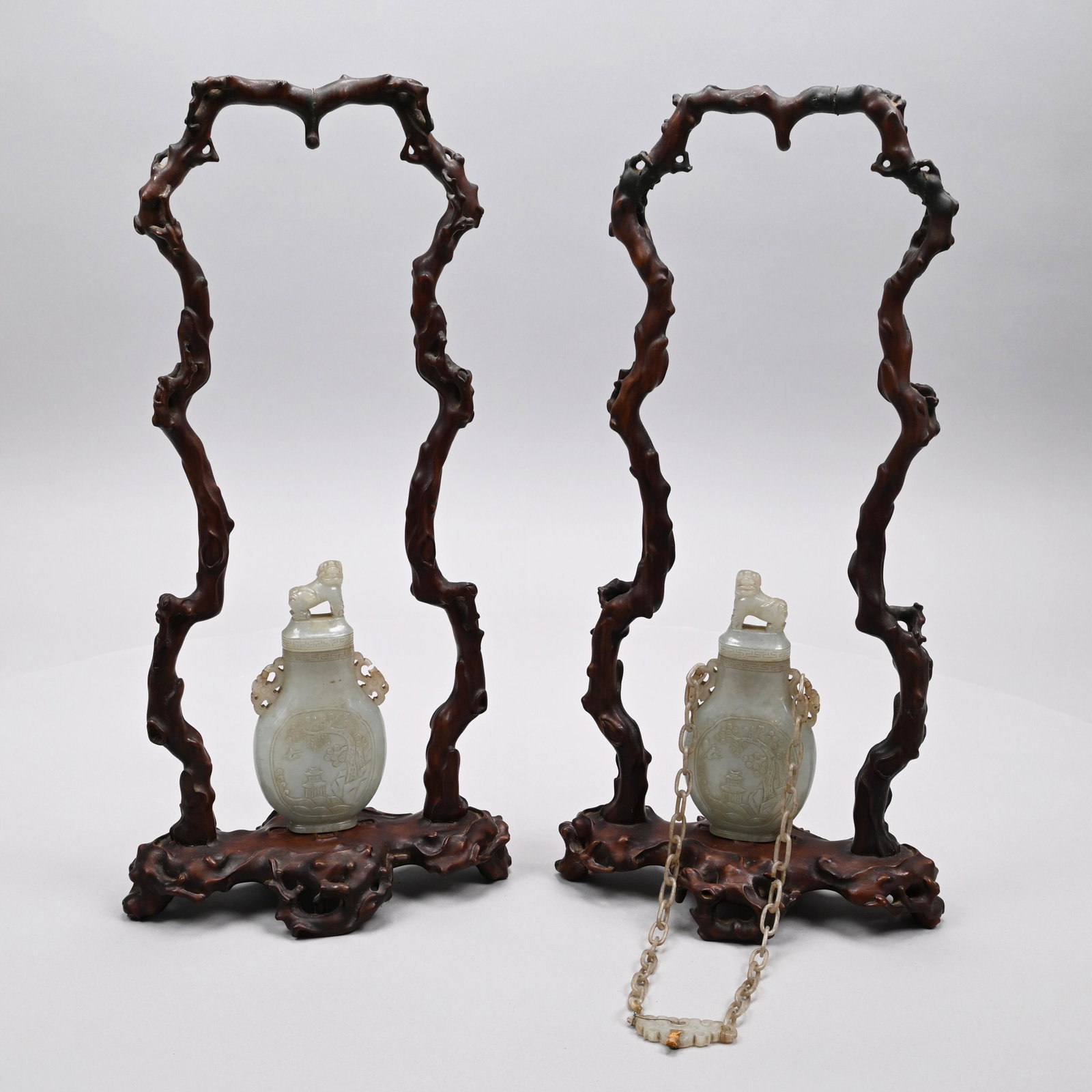 Pair Chinese Hetian Jade Bottles & Covers, Stands: Each of flattened ovoid form, carved on one side with a figure standing under a pine tree, possibly the God of Longevity, Shouxing, and on the other side with a hut near a river under a pine tree, the