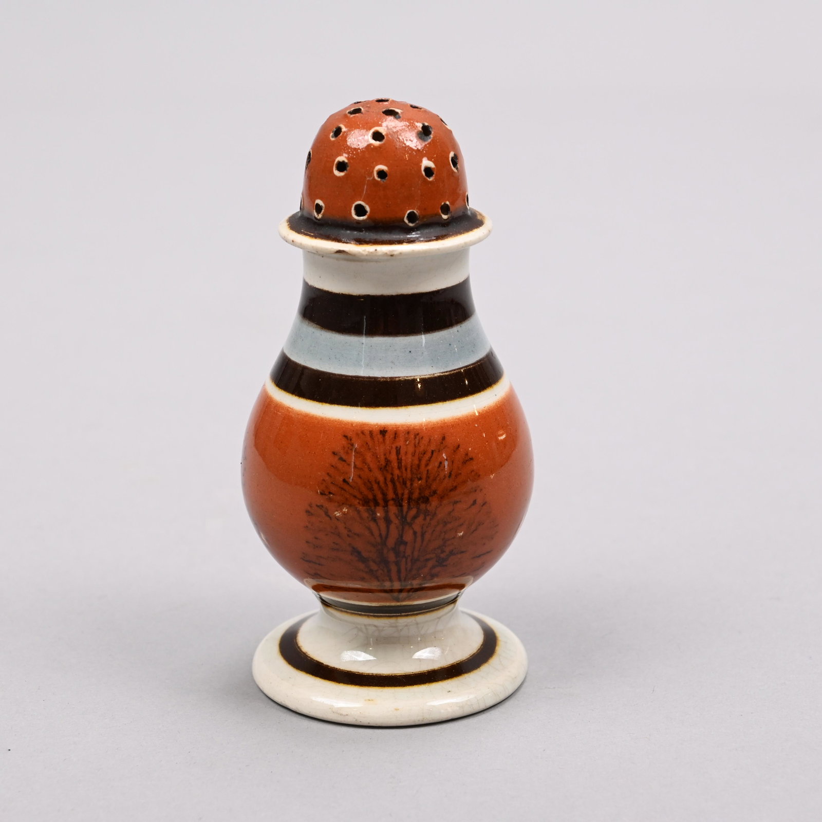 British Pearlware Mochaware Pepper Pot, Circa 1800: British Pearlware Mochaware 'Dendritic' Pepper Pot, Circa 1800. Surrounded by dendritic "seaweed" in black on a pumpkin slip band, the cover matching, within dark brown slip bands and a blue border. H