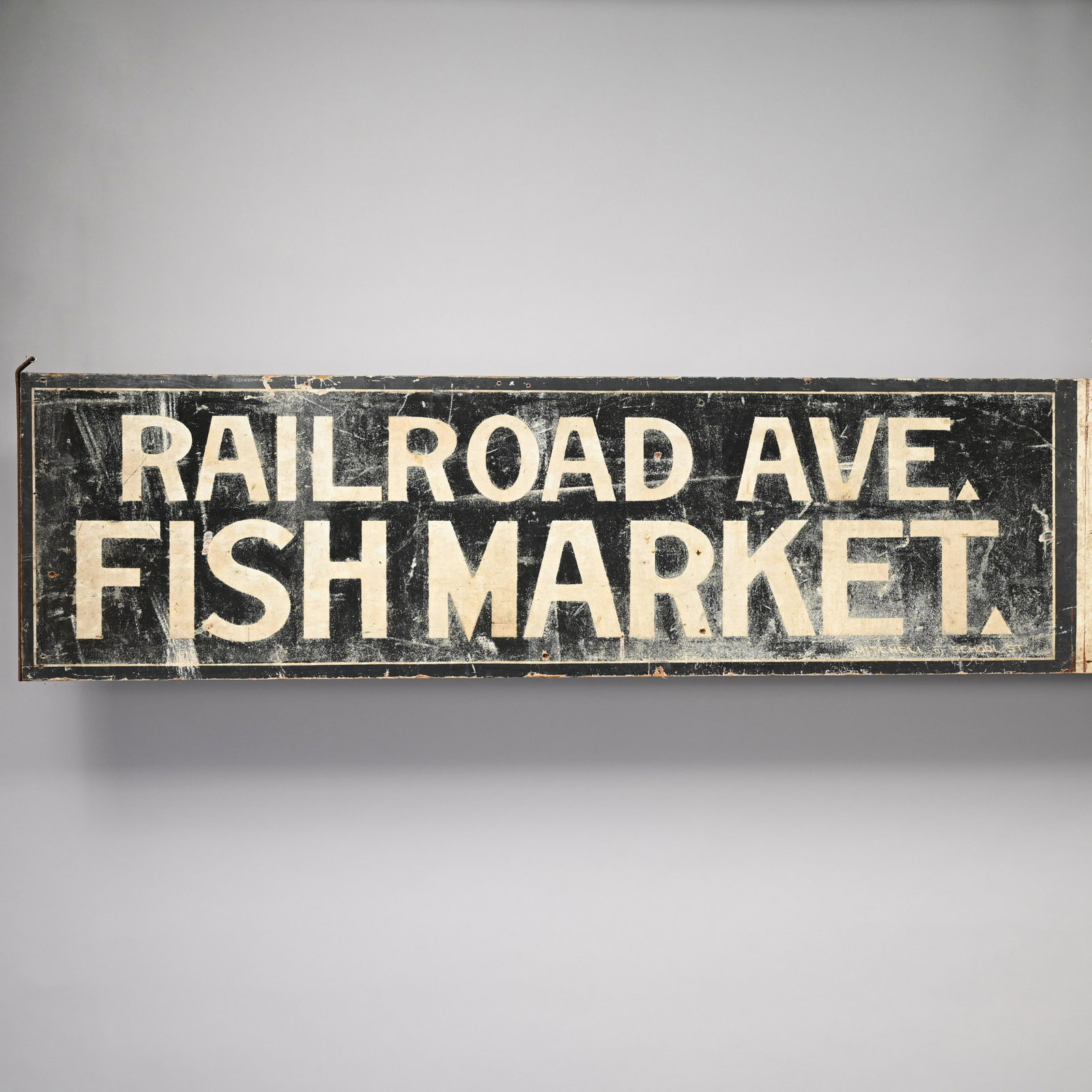 Fish Market Painted Wood Trade Sign: Railroad Avenue Fish Market Trade Sign, Twentieth Century. Painted on each side "RAILROAD AVE FISH MARKET, MITCHELL OF SCHOOL ST" in white lettering on a black ground. H: 17.375 in., W: 77.75 in., D: 
