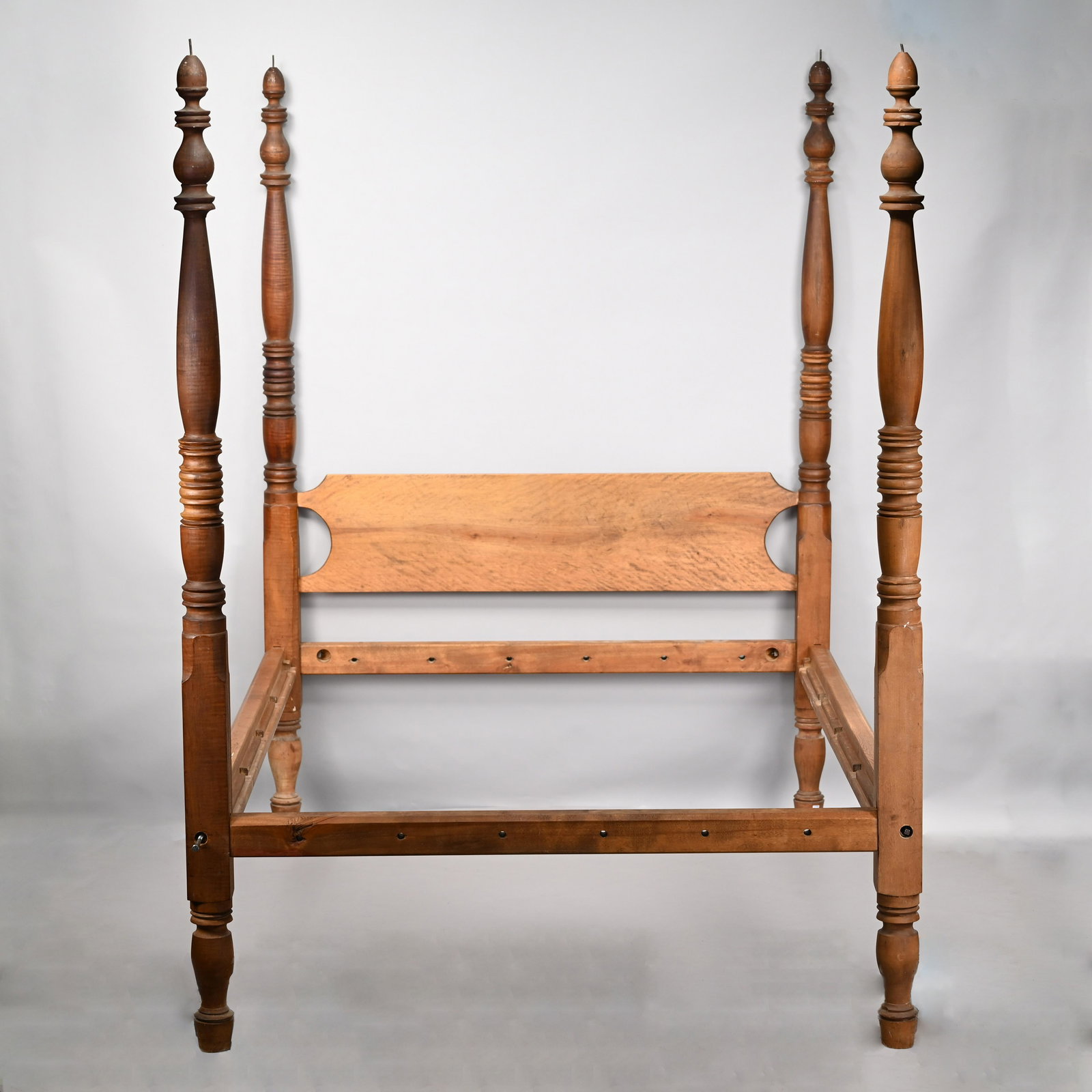 New England Sheraton Maple & Birch Bedstead: Nineteenth Century. Rectangular flame birch headboard, and four vase, baluster and ring-turned posts ending in acorn finials, on collared feet. H: 82.75 in., W: 60 in., D: 84.75 in.