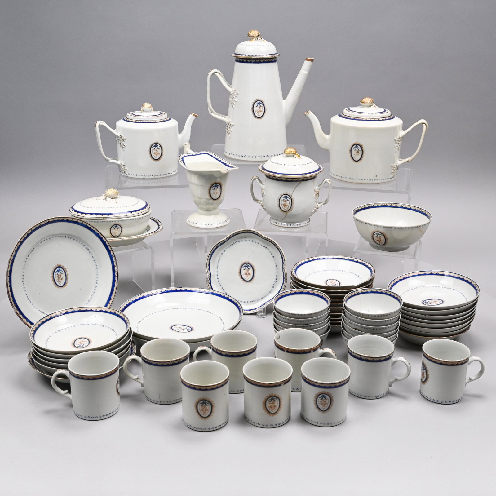 Chinese Export Porcelain Tea and Coffee Service: 1800-10. Comprising two graduated drum-form teapots and covers, a hexagonal teapot stand, lighthouse coffeepot and cover, sugar bowl and cover, helmet-form cream jug, waste bowl, tureen, cover and sta