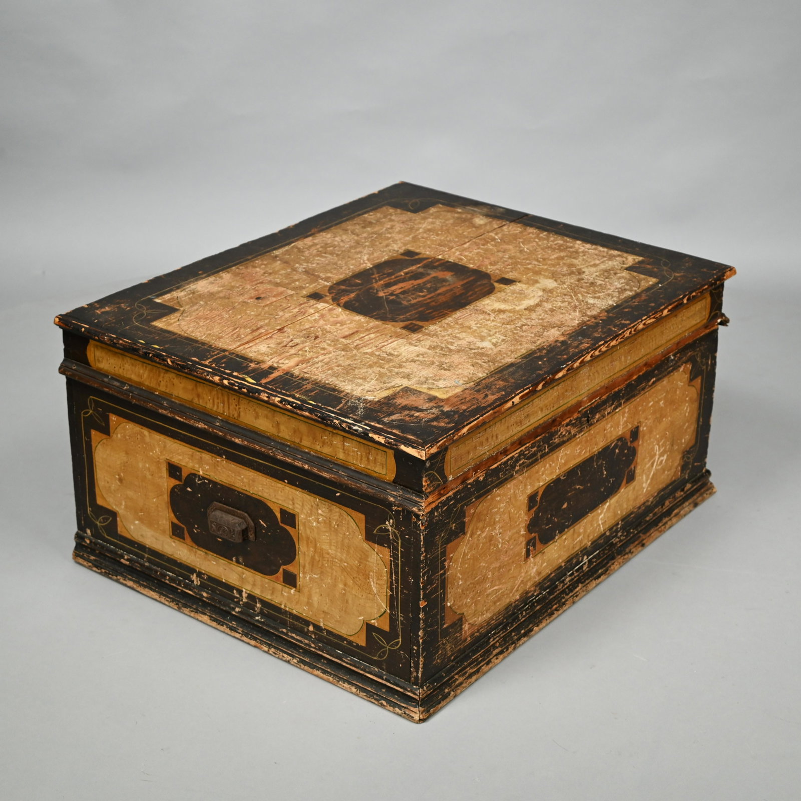 American Paint-Decorated Storage Trunk: Late Nineteenth Century. The top and sides painted to simulate satinwood and reserved with brown panels painted in various geometric patterns, and surrounded by delicate yellow line borders, fitted wi