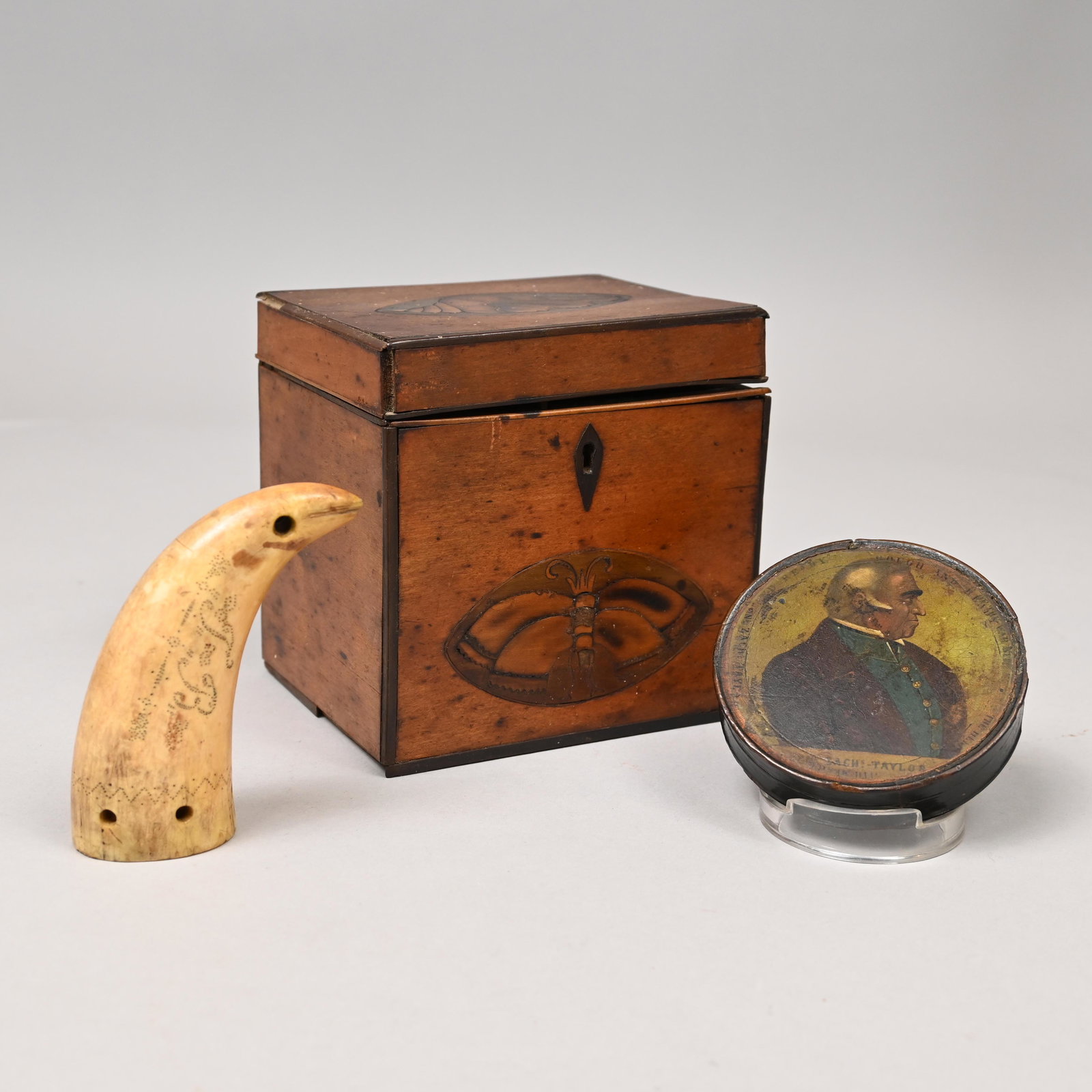 Gen Zach Taylor Snuff Box, Whale Tooth & Tea Caddy: General Zachery Taylor Papier Mache Snuff Box, a Scrimshaw Whale Tooth and a George III Inlaid Mahogany Tea Caddy, Early Nineteenth Century. The snuff box printed in color and inscribed "GENL. ZACHS T