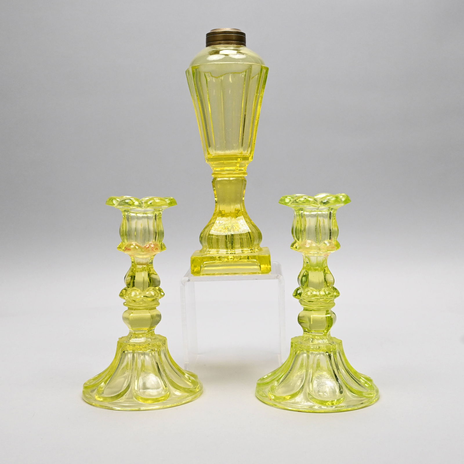Pair Pressed Canary Candlesticks & a Lamp: Pair of Pressed Canary Yellow 'Petal and Loop' Candlesticks, Boston & Sandwich Glass Co., and a New England Whale Oil Lamp, 1840-60. The conical lamp with eight vertical panels joined by a wafer to a