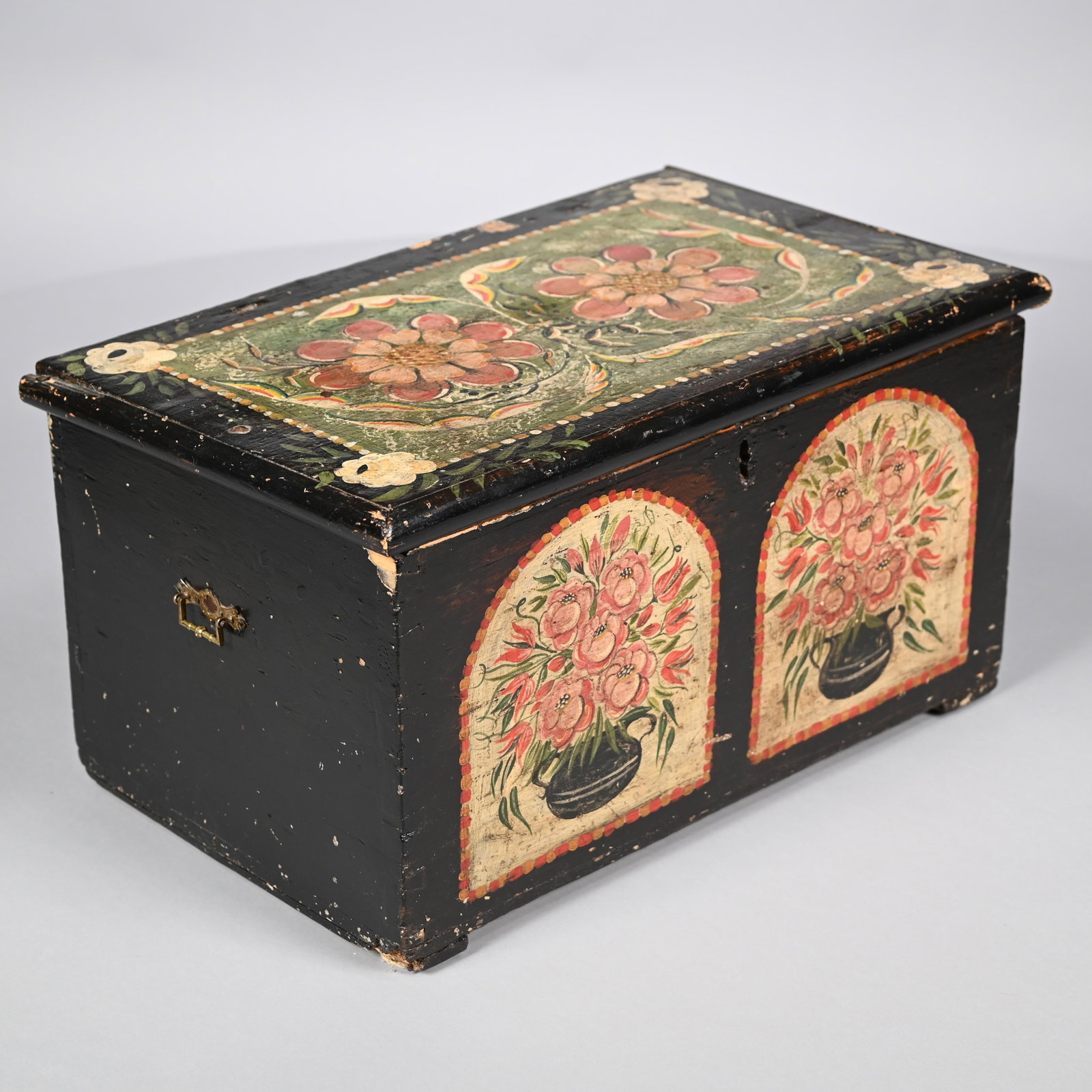 Painted Pine Chest in the Pennsylvania Dutch Taste: Painted Pine Chest Decorated in the Pennsylvania Dutch Taste. Painted in red, green and cream on a black ground, on the lid with two flowerheads within a rectangular border with a flowerhead at each c