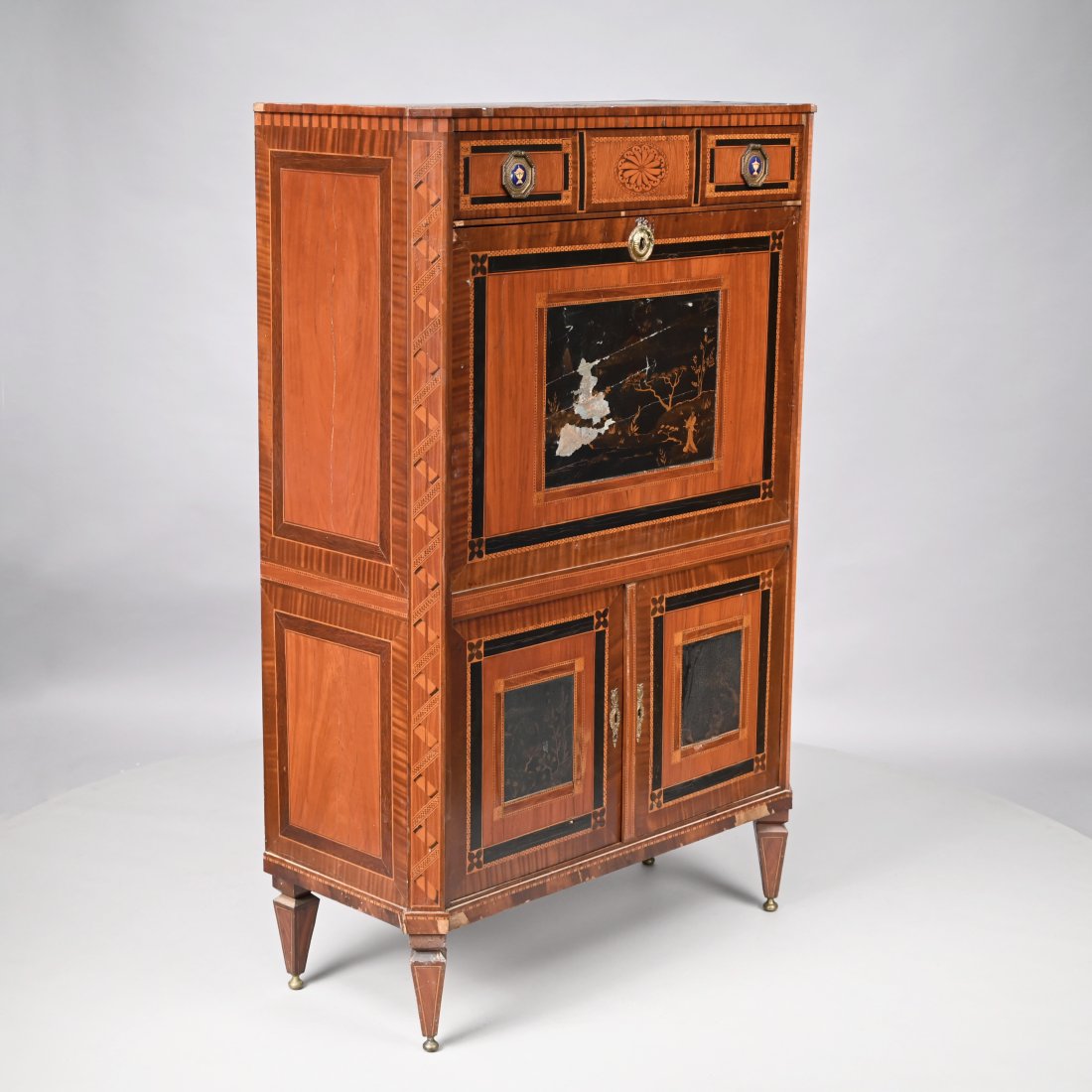 Dutch Neoclassical Mahogany Secretaire Abattant: Early Nineteenth Century. The rectangular top with canted corners above a drawer inlaid to simulate three drawers, mounted on each end with an enamel roundel painted with an urn, and centering a spira