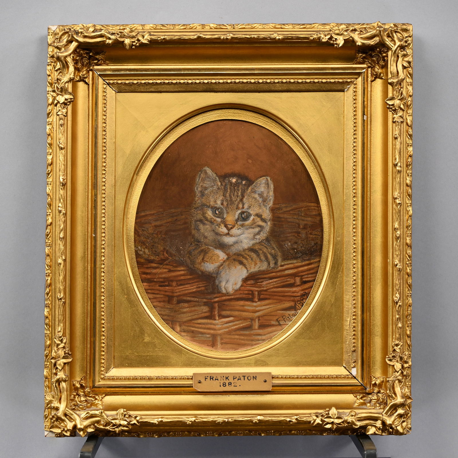 Frank Paton - Portrait of a Tabby Kitten, 1882: Frank Paton (British, 1855-1909). Portrait of a Tabby Kitten, 1882. Oil on thin wood, signed "F. Paton 1882" lower right, (rectangular in oval surround, 12.5 x 10.375 inches). Frame: H: 18.125 in., D: