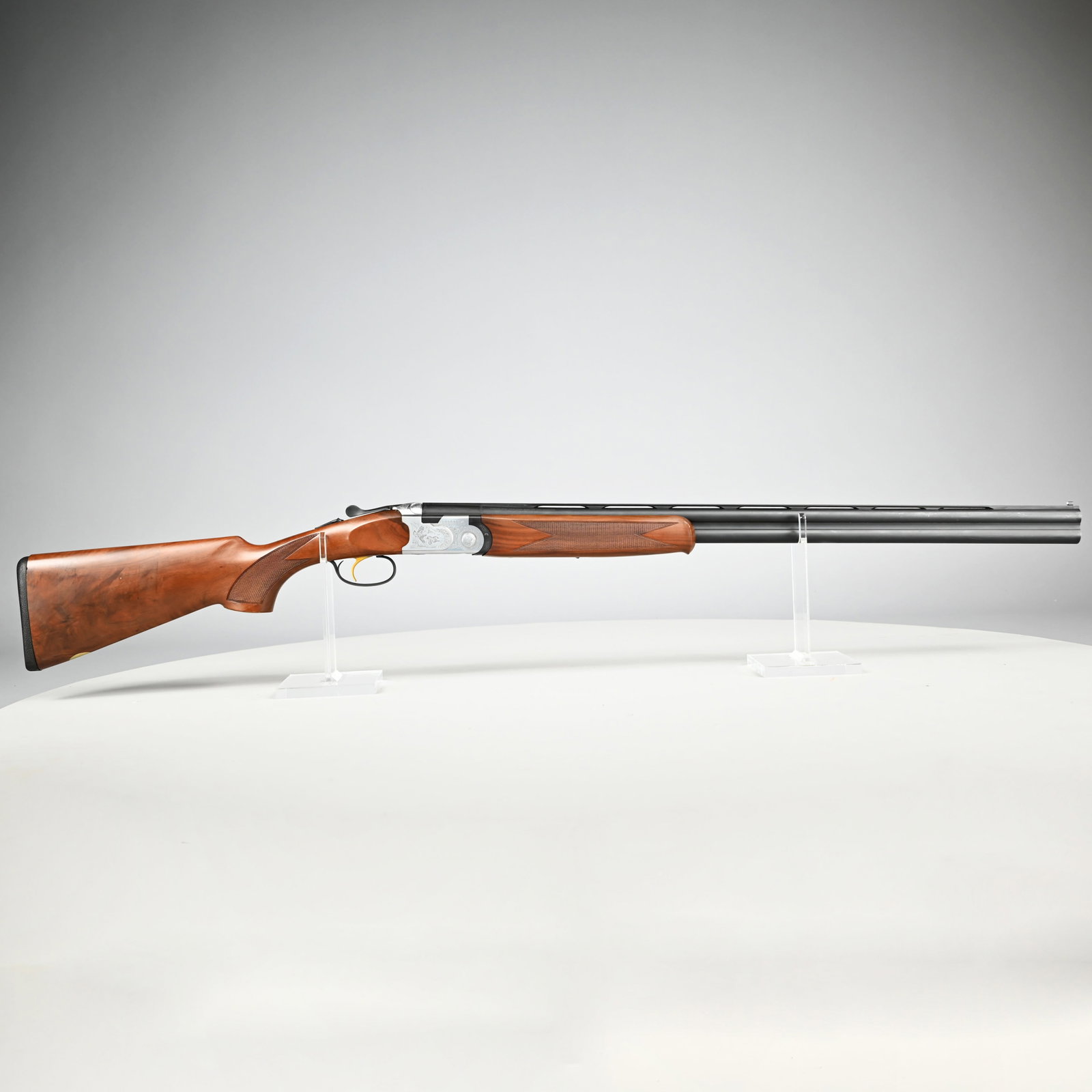 Beretta S687 Silver Pigeon Sporting 20 Gauge O/U: Beretta S687 Silver Pigeon Sporting 20 Gauge Over/Under Shotgun. Serial #M27568B, 2 3/4- and 3-inch shells, the receiver engraved with pairs of game birds, waterfowl and floral scrollwork, flowerhead 