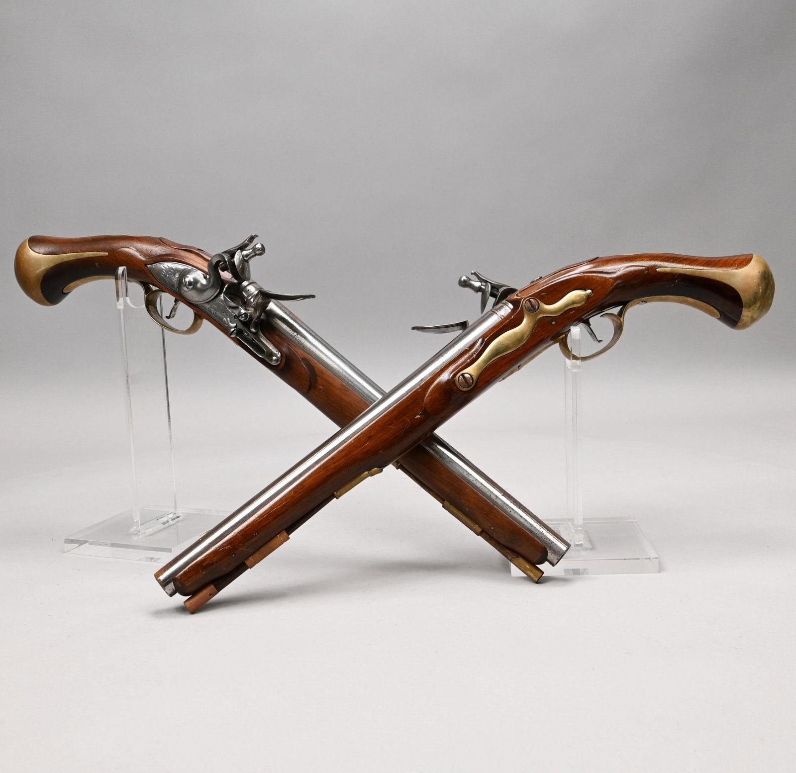 Pair of Wilets British Dragoon Pistol Replicas: Pair of Wilets British Dragoon Pistol Replicas, Encased in a Regency Style Glazed Mahogany Stand. Comprising a pair of accurately reproduced Colonial Williamsburg flintlock pistols, each with walnut g
