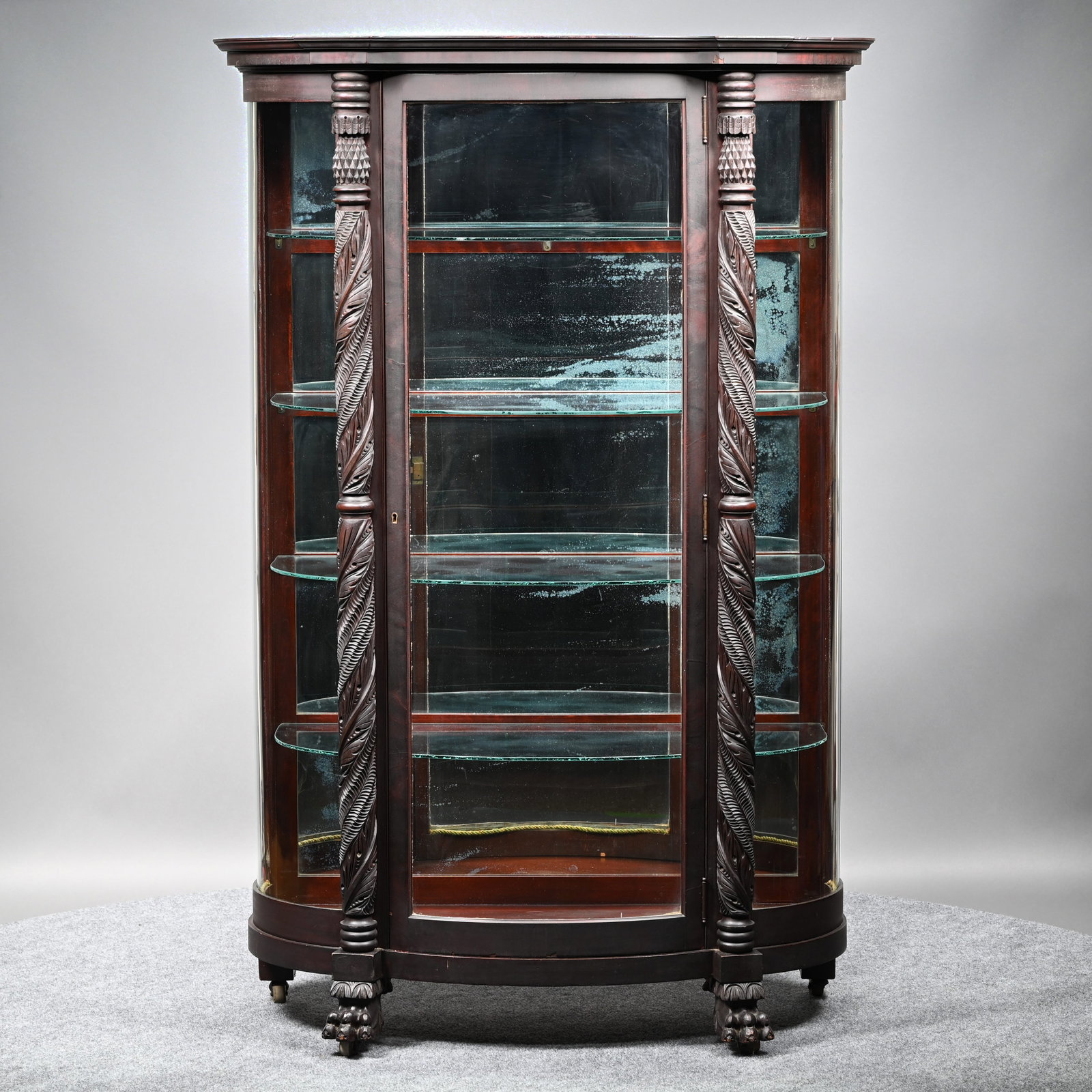 Empire Revival Mahogany China Cabinet: Empire Revival Mahogany China Cabinet, Late Nineteenth - Early Twentieth Century. The molded D-shaped cornice with outset corners above a curved glass door and sides, fitted with four glass shelves, f