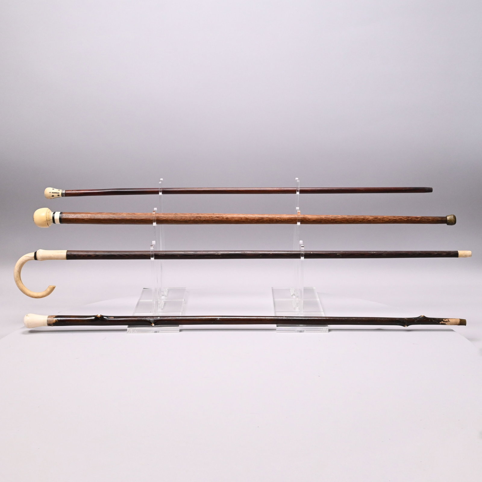 Three Scrimshaw Walking Sticks and a Cane: Three Scrimshaw Whalebone and Wood Walking Sticks and a Cane, Nineteenth Century. The tallest walking stick grip mounted with an 1832 United States dime. Walking stick grip mounted with a dime: L: 34.
