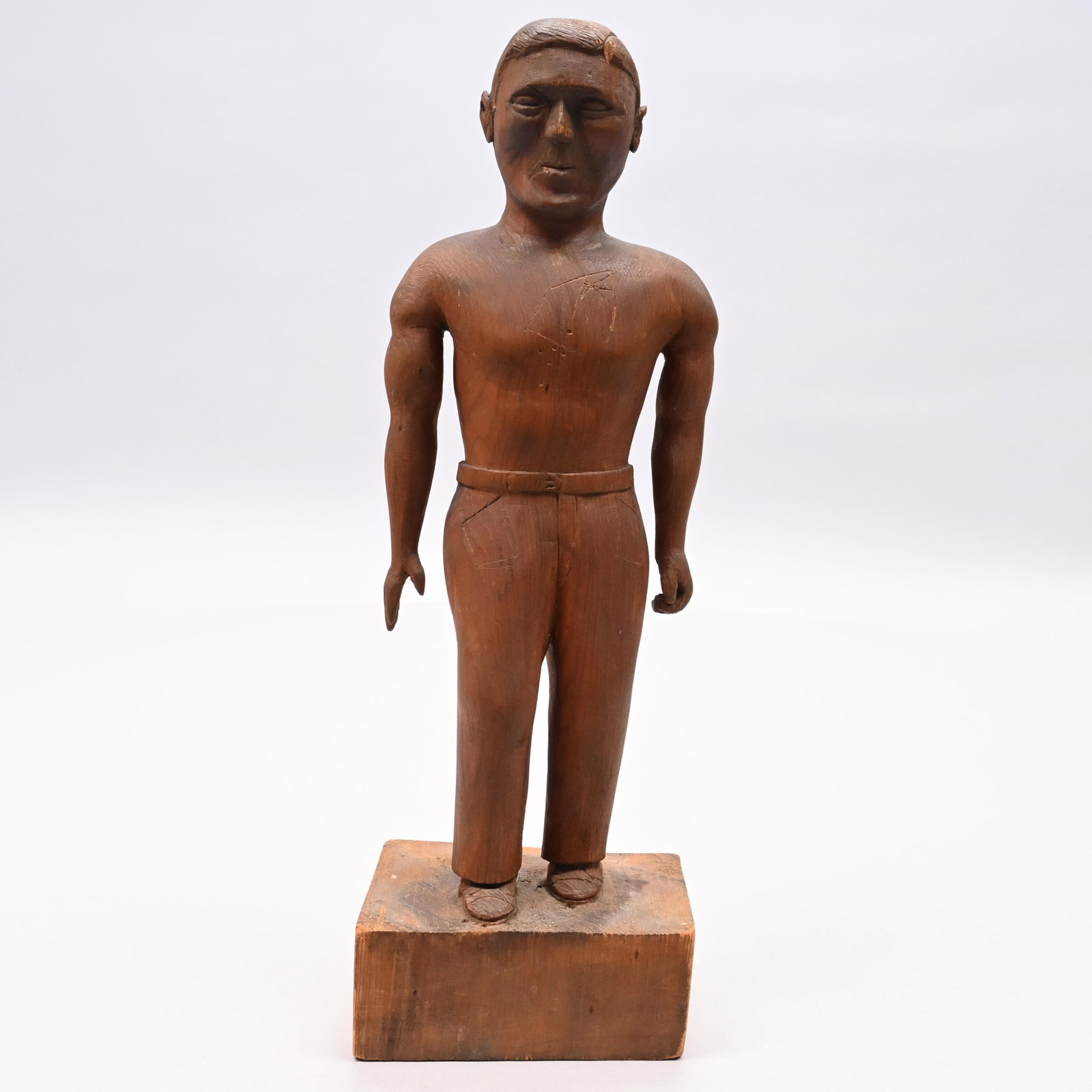 Folk Art Carved Wood Figure of a Man: Folk Art Carved Wood Figure of a Man, Possibly by Joe Thurston from Methuen, Massachusetts. Carved shirtless and wearing jeans, standing on a wood block base, incised initials beneath "CF" and "M." H: