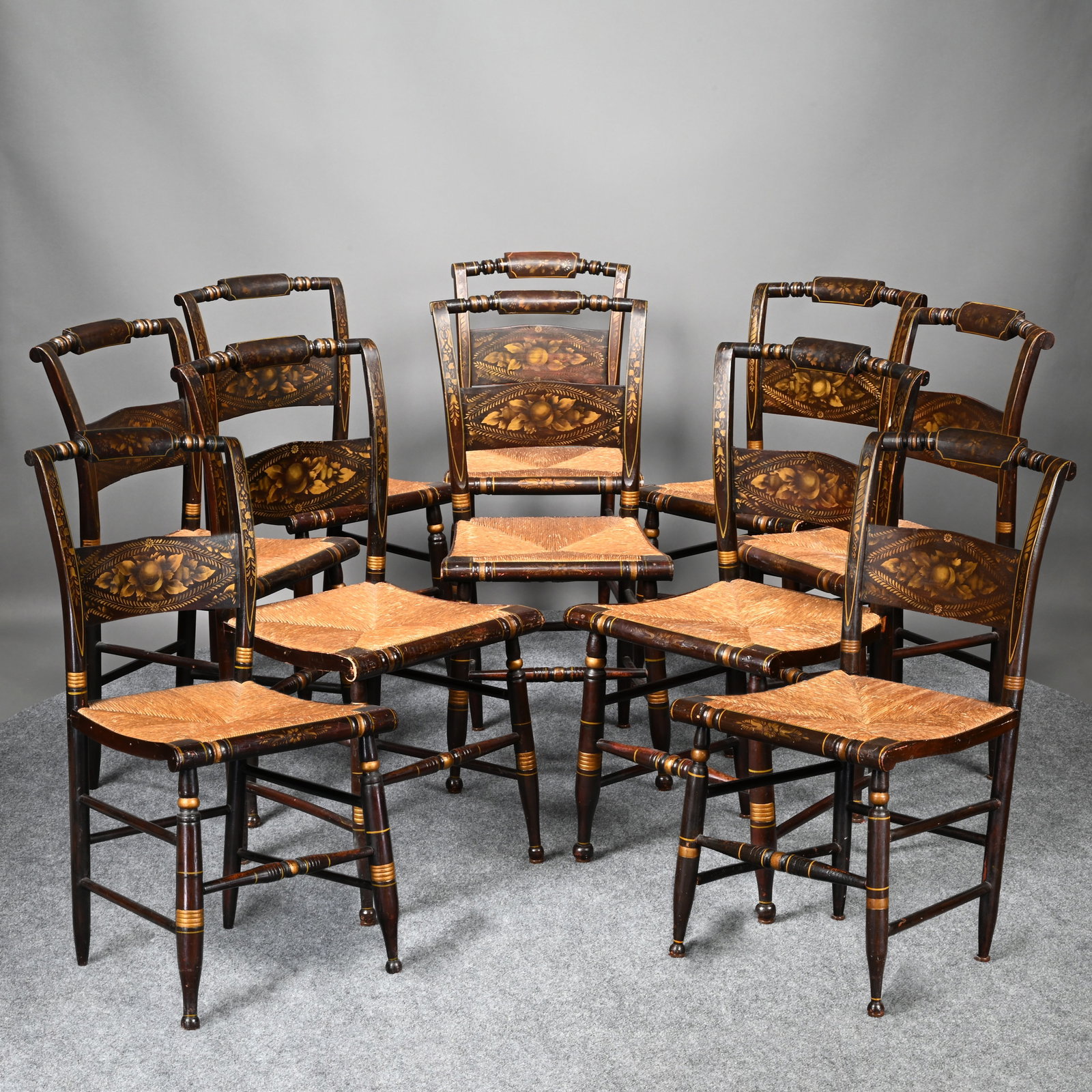 Set of Ten Hitchcock Dining Chairs: Set of Ten Hitchcock Painted and Stencilled Dining Chairs, Nineteenth Century. Stencilled in gold on a black ground, each tablet crest painted with flowerheads within a spool-turned crest rail, the ba